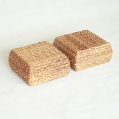 two wicker boxes sitting next to each other on a white tableclothed surface