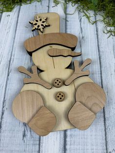 a wooden snowman ornament sitting on top of a table