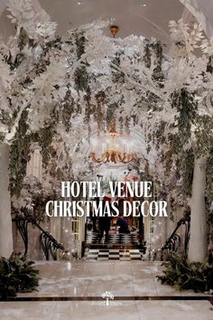 hotel venue christmas decor with white trees and chandelier in the lobby, surrounded by greenery