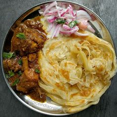 a metal plate topped with meat and onions