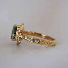 a gold ring with a green stone in the center