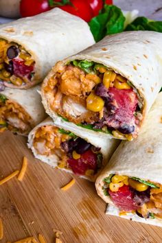 several burritos cut in half on a cutting board