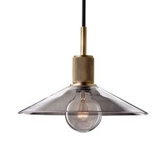 an industrial style light fixture with a clear glass shade on the bottom and gold trim