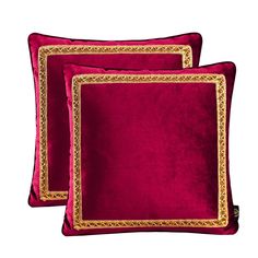 two red velvet pillows with gold trimmings on the sides and one in front