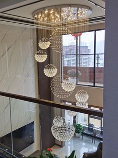 a chandelier hanging from the ceiling in a living room next to a window