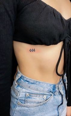 a woman's stomach with the number four tattoo on her left side, and an inscription