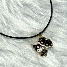 a black and white cat necklace with pink eyes