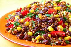 an orange plate filled with black beans, corn and green pepper sprinkles