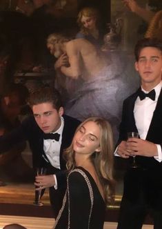 three young people in tuxedos posing for a photo