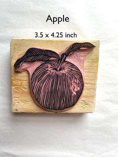 an apple carved into a piece of wood