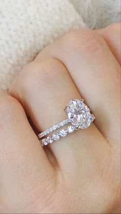 a woman's hand with two engagement rings on it