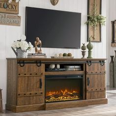 an entertainment center with a fire place in front of a flat screen tv mounted on the wall