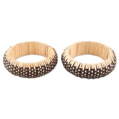 two wooden bracelets sitting next to each other