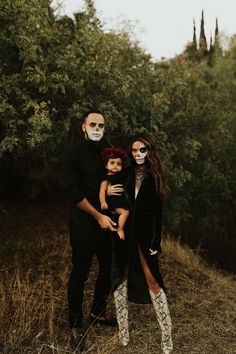 two adults and one child are dressed up in skeleton makeup for the day of the dead