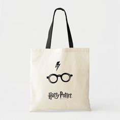 a harry potter tote bag with glasses and lightning bolt in the middle, on a white background