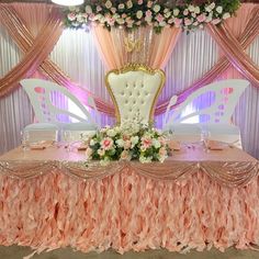 a fancy table with pink and white flowers on the top is set up for a formal function