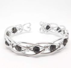 a silver bracelet with black stones on it