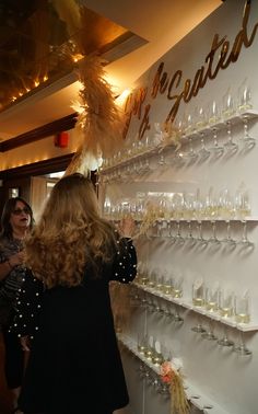 two women looking at wine glasses on display