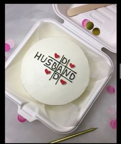 a cake with the words husband and wife on it in a plastic container, surrounded by confetti