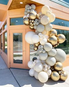 a bunch of balloons that are on the side of a building in front of a door