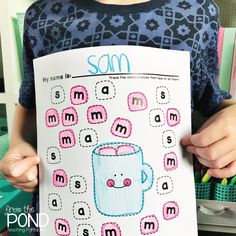 a person holding up a paper with an image of a coffee cup on it and the words sam