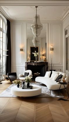 an elegant living room with white furniture and wood floors, chandelier hanging from the ceiling