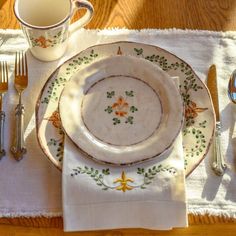 a place setting on a table with silverware and utensils in the foreground