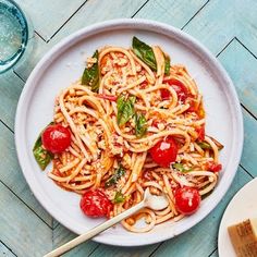 a white plate topped with pasta and tomatoes