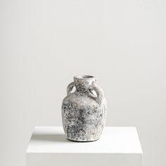 a vase sitting on top of a white pedestal