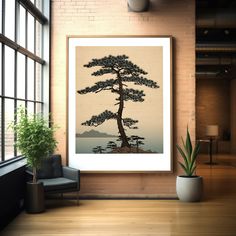 a large poster hanging on the wall next to a chair and potted plant in front of a window