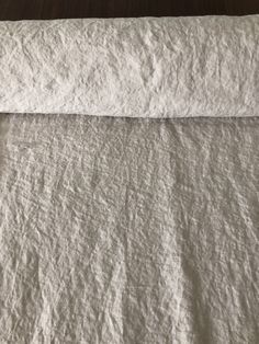 an unmade bed with white linen on it