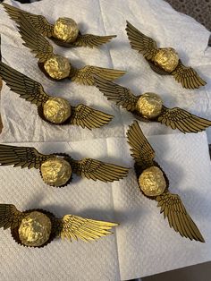 several pieces of chocolate with gold wings on top of paper towels next to each other