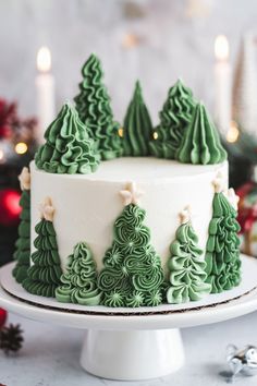 a white cake with green frosting decorated with trees