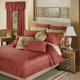 a bed with red and gold comforters in a bedroom