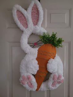 a door hanger with a carrot and bunny ears on it