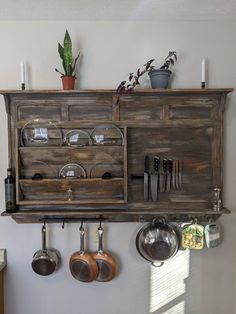 a wooden cabinet with pots and pans hanging from it