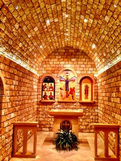 the inside of a church with stone walls and stained glass windows on either side of the alter