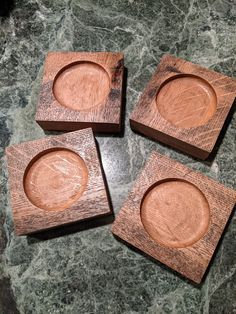 four wooden coasters sitting on top of a green marble counter