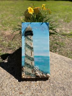 a painting of a lighthouse with flowers in it