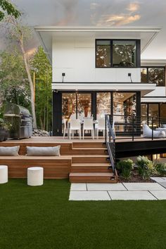 a modern house with wooden steps leading up to the front door and decking area