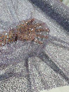 an animal is laying down on the ground covered in silver and black glitters with its mouth open