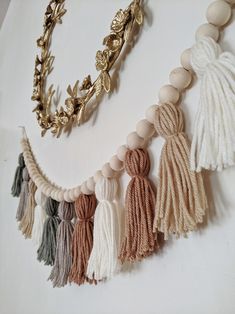 a necklace with tassels and beads hanging from it's side on a white surface