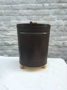 a large black pot sitting on top of a white table next to a brick wall