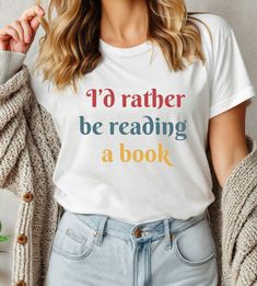 I'd Rather Be Reading a Book Shirt, Book Shirt, Gift for Book Lover, Book Club T-Shirt, Librarian Gift, Reading Shirt, Gift for Reader T-shirts are Bella + Canvas 3001 Unisex * Solid colors are 100% combed and ring-spun cotton (heather colors contain polyester) * Fabric weight: 4.2 oz/yd² (142 g/m²) * Pre-shrunk fabric * Side-seamed construction * Shoulder-to-shoulder taping SIZING All products are unisex sizes and not women's fitted shirts - if you prefer a fitted look, we suggest sizing down. Book Shirt, Gift For Book Lover, Fitted Shirts, Gifts For Librarians, Reading Shirts, Club T Shirt, Reading A Book, Book Shirts, Gifts For Readers