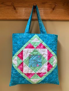 "This quilted color block tote bag uses brights and whites to make up the matching block quilt design on both sides of the bag. I quilted it in one piece before assembling the bag and lining it with a coordinating gray and white polka dot fabric. There is an inner layer of cotton canvas sandwiched between to add sturdiness to the bag and give it a more cushioned feel. The beautiful colors of turquoise, hot pink, mint green and white give this bag a modern mosaic vibe. This tote is a generous siz Green Quilted Square Bag, Square Green Quilted Bag, Blue Quilted Rectangular Bags, Color Block Tote Bag, Modern Mosaic, Bright Quilts, Color Block Tote, Block Quilt, Modern Mosaics