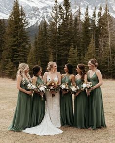 a group of women standing next to each other on top of a grass covered field