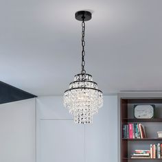 a chandelier hanging from the ceiling in a room with bookshelves and shelves