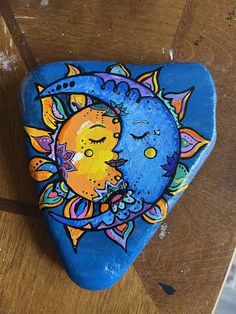 a painted rock sitting on top of a wooden table