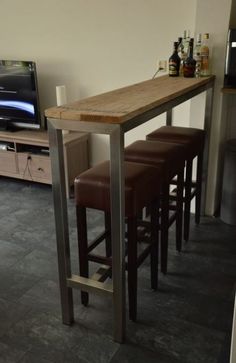 three stools are sitting at the bar with a television in the background