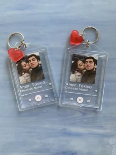 two clear plastic keychains with an image of a man and woman on them